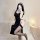 Woman in black plus size punishment nun lingerie set with cut-outs, high slit, and thigh-highs, posing for mirror selfie.