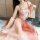 A woman wears a chinese hanfu lingerie set featuring a peach-colored top with floral embroidery and a flowing skirt, embodyin...