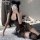 A woman poses seductively wearing a black lace catwoman sleepwear with butterfly tie-up design, perfect for adult bedroom lin...