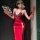 A woman poses elegantly in a red qipao-style dress with lace detailing, holding a decorative fan. the outfit features cutouts...