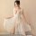 A woman poses elegantly wearing a sheer lace cami dress, featuring delicate floral embroidery and a flowing design, perfect f...