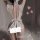 Woman wearing white guan yun plus size lingerie set with lace trim, deep v-back, and bow detail in soft bedroom setting.