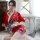 A woman poses elegantly in a red floral japanese kimono, holding a fan, showcasing a sexy and playful role play outfit.