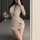 A woman poses in a deep v lace sheer babydoll nightgown, featuring adjustable straps and a bodycon fit, holding a glass of wi...