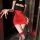 Woman wearing red and black night-silk seductive secretary outfit with lace stockings, posing in dimly lit room.