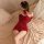 A woman lounges on a bed wearing a red sparkly dress with a bow tie, perfect for festive occasions like christmas and new yea...