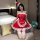 A woman poses in a festive christmas-themed outfit, featuring a red maid costume with lace details and a santa hat. the ensem...
