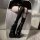 Black over-the-knee fishnet stockings featuring lace-up thigh highs with bow accents, perfect for a sweet yet edgy look.