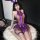 Woman wearing purple lace bunny girl lingerie set with ears, garter belt, and sheer stockings on white rug.
