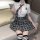 Woman wearing a white shirt and plaid skirt, styled as a cute japanese school uniform set.