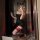 Woman in black lace mesh crop top dress with bunny ears, posing for mirror selfie.