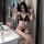 Woman wearing black ai ru ru sexy lingerie set with bondage-style straps, posing in bathroom mirror.
