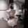 A woman sits facing away from the camera, wearing an elegant ancient chinese hanfu costume set inspired by qin-han dynasty at...