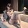 Woman wearing chaomu jk sailor outfit - sheer mesh bodysuit with sailor collar, thigh-highs, and blindfold, lounging on sofa.