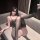Woman wearing chaomu sensual lingerie set with sheer black bodysuit, stockings, and pearl insertable design on sofa.