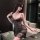 Woman wearing chaomu sexy lingerie set - sheer black strap cami bra with lace trim and peekaboo cutouts, holding wine glass.