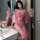 A woman poses elegantly in a pink cherry blossom-themed hanfu-inspired lingerie set, featuring sheer fabric and floral patter...