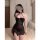 A woman models a black sheer mesh lace halter dress featuring a side slit, perfect for seductive evening wear.