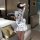 A woman stands facing away from the camera, wearing a white chinese new year dress inspired by red silk. the dress features a...