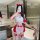 Woman in red and white christmas lingerie set with bow details, posing in a modern bathroom.