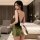 Woman in green velvet christmas sleep dress with deep v back and white bow, retro erotic nightwear for new year.