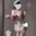 Woman in white maid apron with red bow, backless design, and cheeky cutout holding a glass of milk.