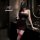 Woman in dark romance lace mesh cheongsam set with sheer rose halter corset and high-waisted thong bodysuit, holding wine gla...