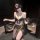 Woman wearing elegant black fringe lingerie set with sheer skirt, gold coin belt, and feather fan—sensual exotic-style intima...