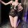 Woman kneeling in black feiniao moonbird lace bodysuit with floral details and open-crotch design.