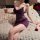 Woman in purple feiniao moonlit bird lace chemise with floral embroidery, holding wine glass on rose-petal bed.