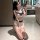 A woman poses in a bathroom wearing a white and blue sailor-style bikini top with a large bow, paired with matching shorts, c...