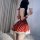 A woman poses in a festive red dress adorned with white polka dots, featuring a fluffy hem and tie-backs, perfect for new yea...