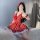 A woman poses with a phone, wearing a red polka dot dress featuring a bow and fluffy trim, paired with matching accessories. ...