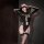 Woman wearing black golden night seductive knit bodysuit with sheer mesh, lace-up front, garter straps, and thigh-high stocki...