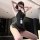Woman in black bodycon mini skirt and halter top, wearing a lanyard with id badge, posing seductively indoors.