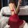 A woman poses in a red guiyun new year silk sleep dress featuring a deep v back design and built-in pads, exuding elegance an...