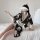 A woman sits on a bed wearing a black floral japanese kimono-style lingerie set, featuring playful fox-themed design elements...