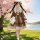 A girl in a cute japanese lolita dress stands by a cherry blossom tree, holding a plush rabbit. the dress features soft ruffl...
