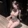 Woman wearing jinxiao sheer mesh bodysuit with lace trim, cut-out front, fishnet stockings, and blindfold.