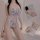 Woman wearing blue floral lace sheer bodysuit with crisscross straps, shown from front and back views.