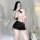 Woman modeling lemon story seductive air hostess costume with white crop top, black tie, and skintight pencil skirt in bedroo...