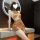 Woman wearing sheer vintage-inspired cheongsam sleepwear with cut-outs, high slit, and chest detailing in warm-toned lingerie...