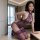 Woman modeling purple lace cheongsam lingerie set with sheer vintage design and bare-chest detail in modern room.