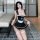 A woman models a linglinting maid costume set, featuring a black and white ruffled apron dress with thigh-high stockings, per...