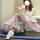 A person wearing a lolita-style dress featuring a voluminous crinoline petticoat, lace stockings, and black shoes, sitting ca...