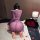 Woman kneeling in purple feiniao moon gazer sheer long sleeve bodycon dress, surrounded by rose petals and red roses.