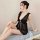 A woman poses elegantly in a sheer black lace sleepwear set, featuring delicate ruffles and a plunging neckline, perfect for ...