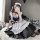 A woman poses in a black and white maid costume, featuring ruffles and bows, perfect for cosplay or anime-themed outfits.
