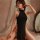 A woman poses elegantly in a black meinaier sexy lace nightgown set, featuring a sheer lace design with a halter neck and thi...