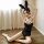 Woman modeling black lace bunny bodysuit with open-crotch design and hidden snap closure, posing on floor with ears up.